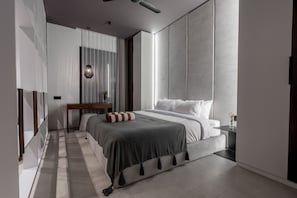 Un dormitorio moderno con una cama grande, una mesita de noche y un tocador.