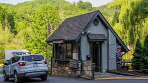 A small, stone building with a sign reading "SECURITY" and an American flag.
