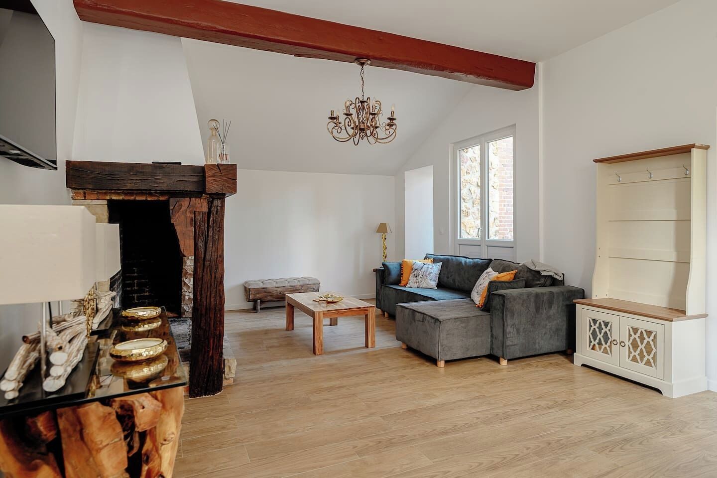 Una sala de estar con chimenea, un sofá, una mesa de centro y un aparador de madera.