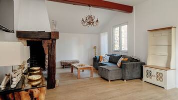 Una sala de estar con chimenea, un sofá, una mesa de centro y un aparador de madera.