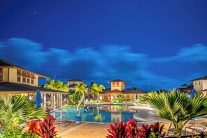 A nighttime resort pool area with a clear view of the pool, surrounding greenery, and adjacent buildings. - Pili Mai Family Condo 12F, 2 Bedroom 2.5 Bath, Ground Floor, Sleeps 6 (Koloa)
