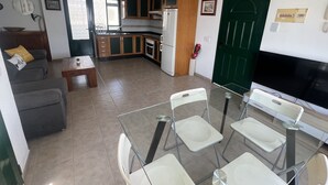 A compact living space with a kitchenette, a sofa, a dining table with chairs, and a TV. - HOUSE LA ESTRELLA PLAYA BLANCA LANZAROTE (Playa Blanca)