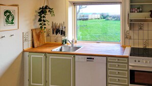 Una cocina con encimera de madera, un fregadero y un lavavajillas.