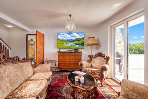 A spacious living room with a large flat-screen TV, ornate furniture, and a view of the outdoors. - Hidden Pool House With Sea View (Novi Vinodolski)