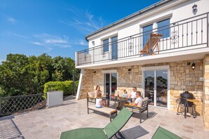 A two-story house with a balcony, outdoor seating, and a barbecue area. - Hidden Pool House With Sea View (Novi Vinodolski)