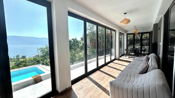 Une chambre moderne avec de grandes fenêtres, une piscine et un canapé.