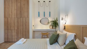 Una camera da letto moderna con un letto grande, un armadio in legno, uno sgabello e uno specchio a muro.