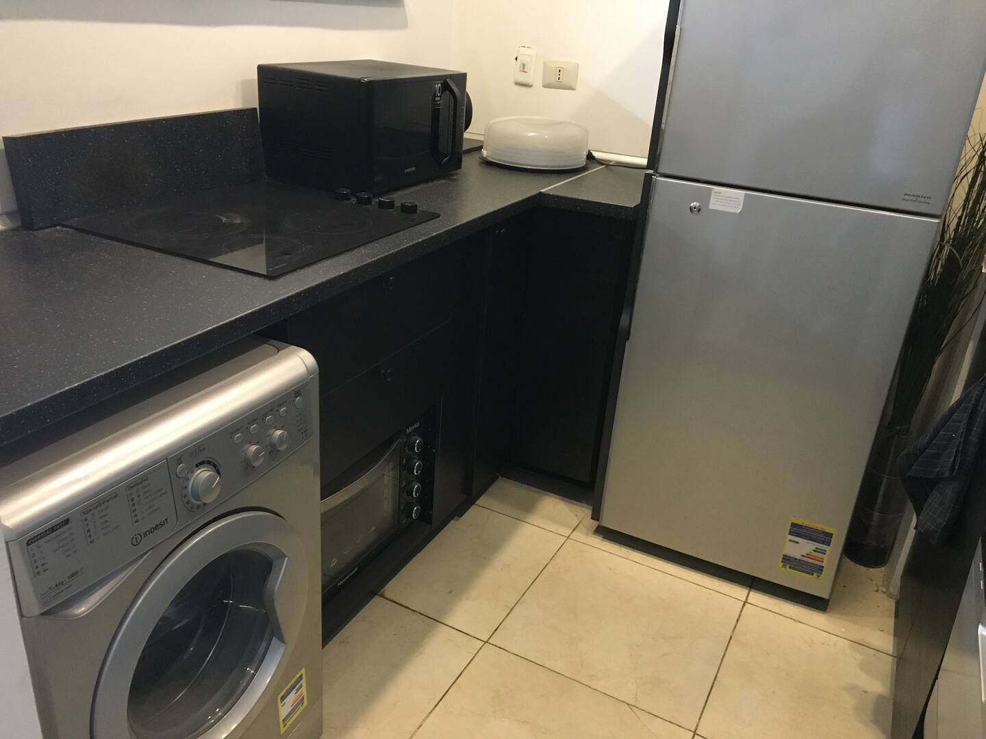 A compact kitchenette with a microwave, toaster, and refrigerator.