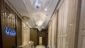 A hotel lobby with a chandelier, a reception desk, and a sign for 'Youth New Car'. - MISK properties 2 bedroom duplex 2 (Cairo Governorate)