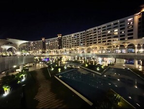 Un hôtel moderne à plusieurs étages, doté d’une cour intérieure avec une piscine et d’une galerie couverte.