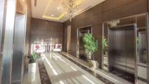 A modern lobby with a central walkway, potted plants, and elevators. - MISK properties 2 bedroom duplex 2 (Cairo Governorate)