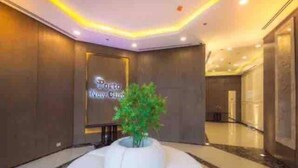 A hotel lobby with a reception desk, a large potted plant, and a sign reading "Porto New City". - MISK properties 2 bedroom duplex 2 (Cairo Governorate)