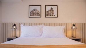 A neatly made bed with white linens and a brown throw blanket, flanked by two bedside tables with lamps, each table holding a phone and a remote control. - w Bright 1BR w Balcony in Miraflores (Lima)