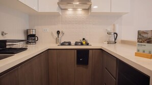 A modern kitchen with white cabinets, stainless steel appliances, and a black towel hanging on the door. - w Bright 1BR w Balcony in Miraflores (Lima)