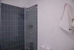 A bathroom with a glass shower enclosure, a white toilet, and a towel hanging on a rack. - w Charming 2BR w Balcony in Miraflores (Lima)