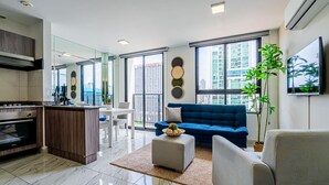 Un apartamento moderno con cocina, sala de estar y ventanas amplias que ofrecen vistas a la ciudad.