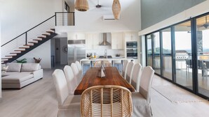 A modern kitchen with white cabinets, stainless steel appliances, and a large island. - w Breathtaking 9BR Villa in Costa Rica (Cabo Velas)