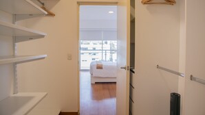 A hotel room with a bed, a wardrobe, and a view of the outside. - Stunning 1BR With Great Deco in Miraflores (Lima)
