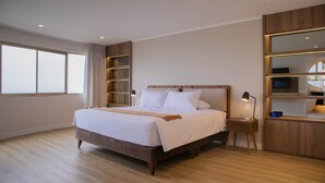 Un dormitorio moderno con una cama grande, estanterías empotradas y una mesita de noche con lámpara.