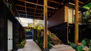 A modern architectural interior with a central staircase, wooden beams, and a glass door entrance. - w Spectacular 4BR Villa in Costa Rica (Jacó)