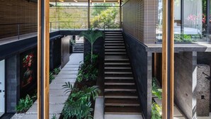 A modern architectural interior with a wooden ceiling structure, a central staircase, and surrounding greenery. - w Spectacular 4BR Villa in Costa Rica (Jacó)