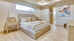 Un dormitorio con una cama grande, un ventilador de techo, una ventana y un cuadro en la pared.
