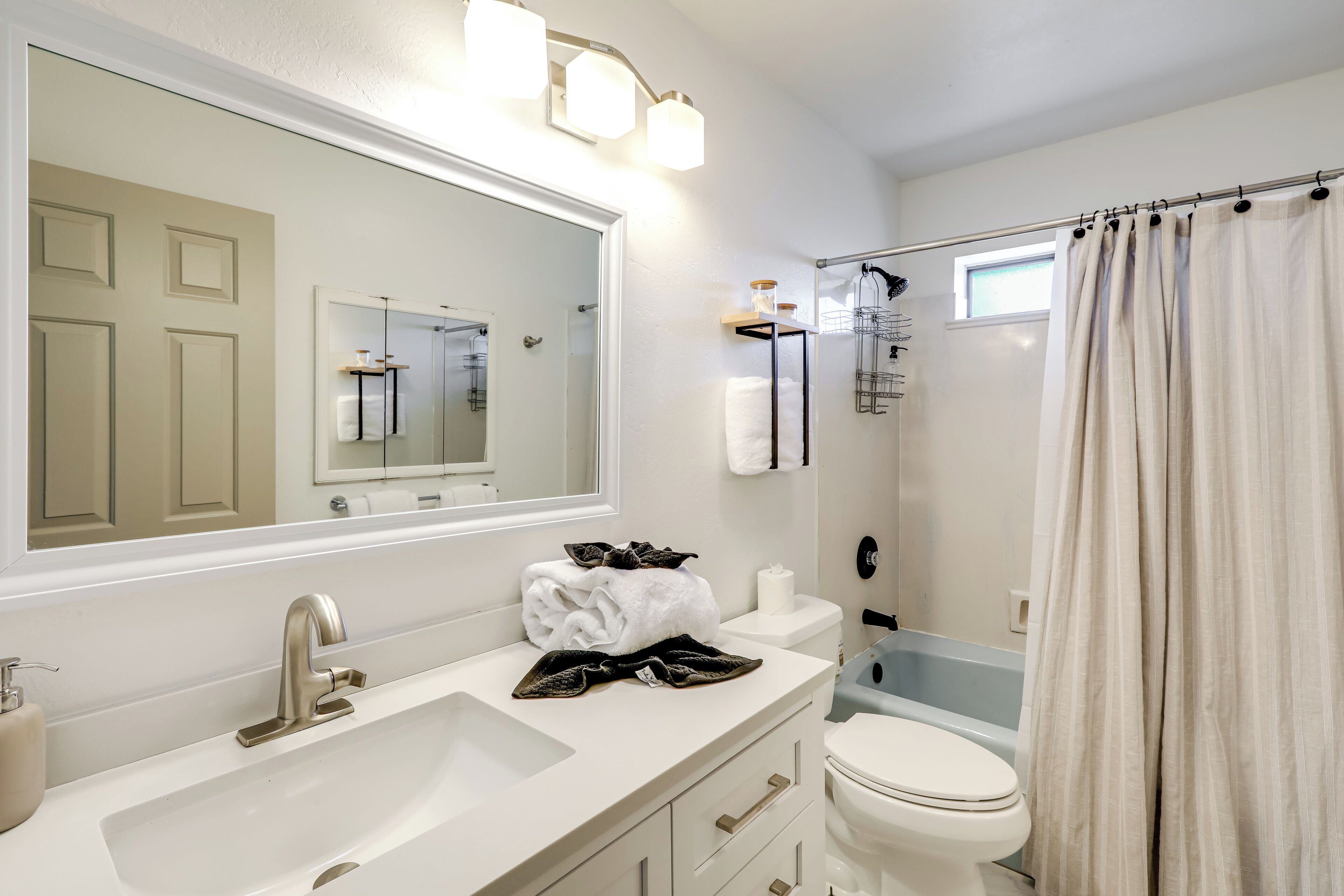 A bathroom with a sink, toilet, and shower.