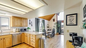 Una cocina moderna con armarios de madera, microondas y una estación para café.