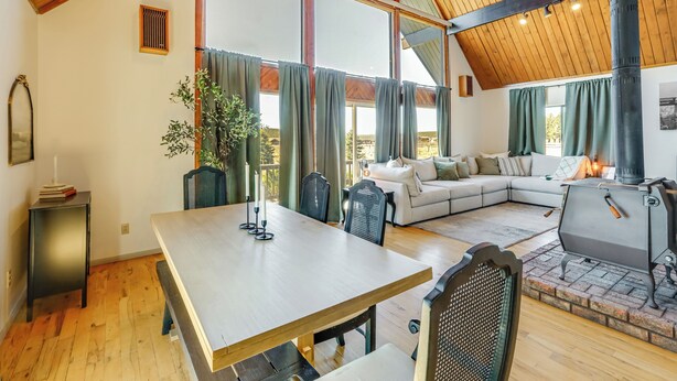 Amplia sala de estar con una gran mesa de madera, un sofá y una chimenea.