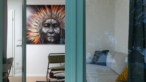 A modern living room with a large painting, a sofa, and a chair. - Holiday Home Olive&sun (Zupa dubrovacka)