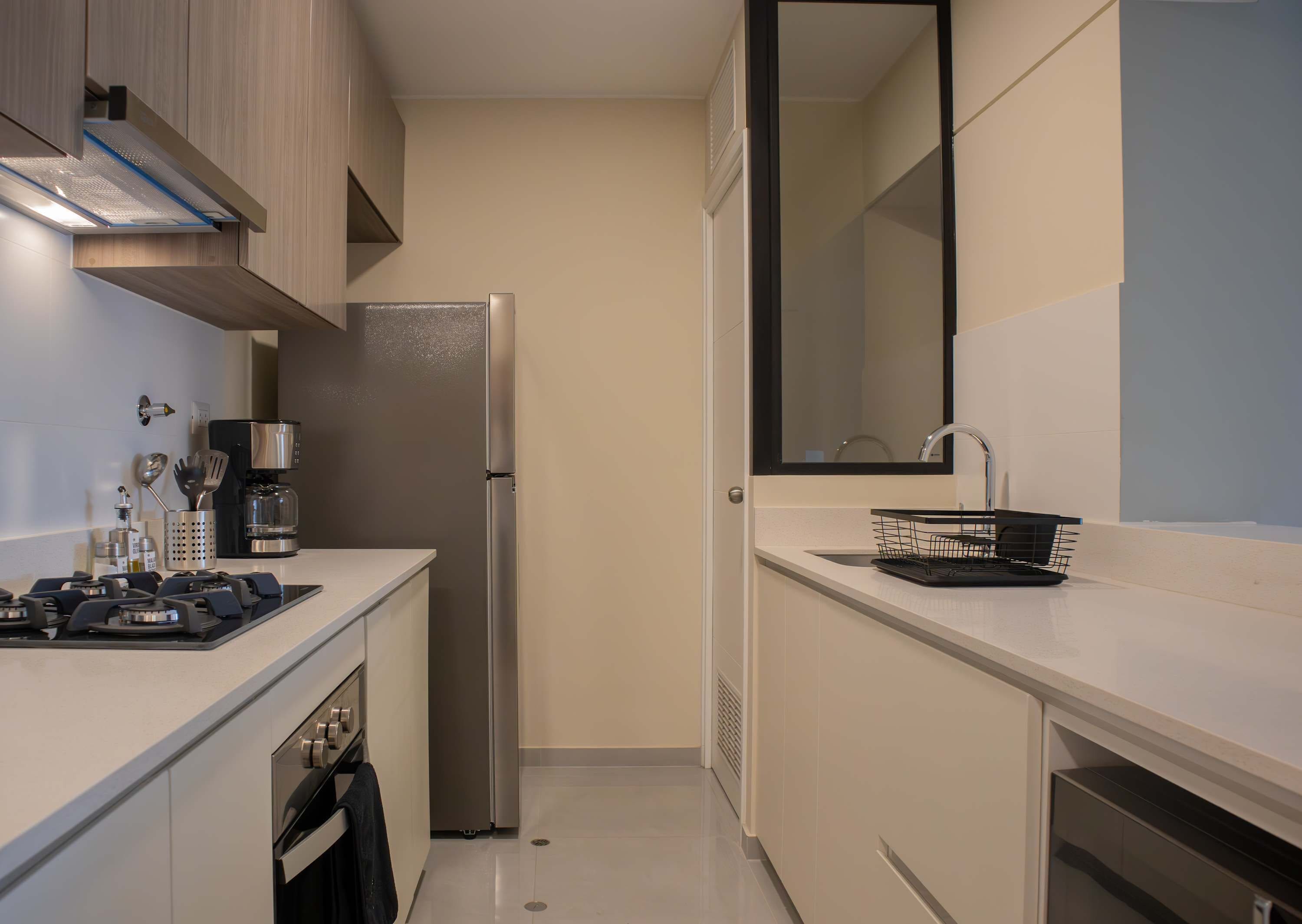 A modern kitchen with a stainless steel refrigerator, a coffee maker, and a built-in oven.