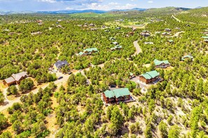An aerial view of a forested area with multiple cabins and houses, some with green roofs, surrounded by dense trees and open spaces. - Hot Tub, Game Room: Mtn-view Cabin 9 Mi to Zion (Orderville)