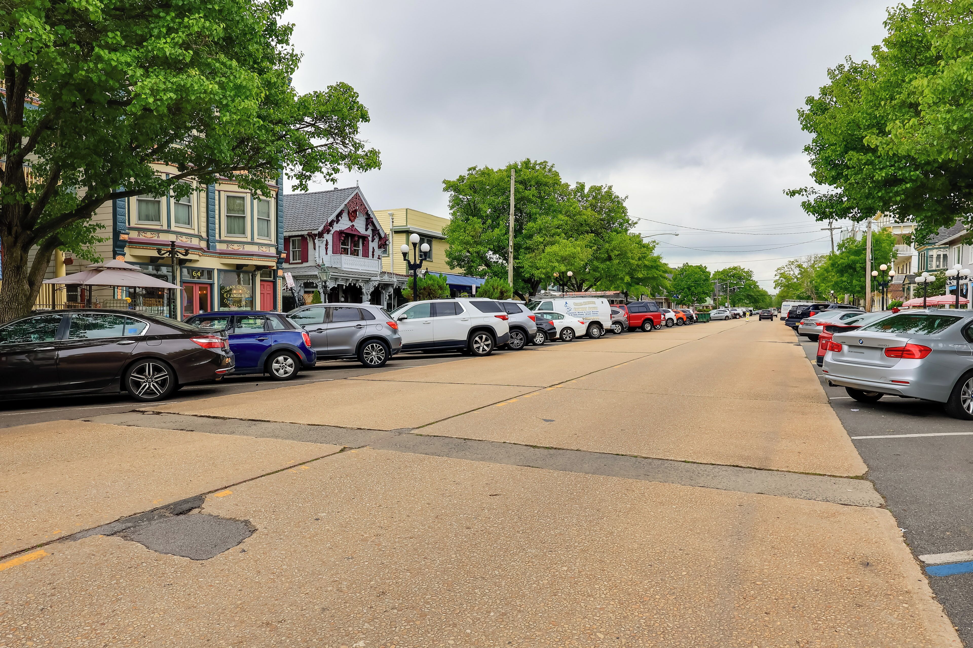 A street lined with parked cars and historic buildings.