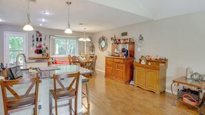 A spacious kitchen with wooden cabinets, a dining area with chairs, and pendant lighting. - 5 Mi to Lewisville Lake: Couple's Retreat w/ Yard (Lewisville)