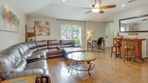 A spacious living room with a sectional sofa, a round coffee table, and a dining area with bar stools. - 5 Mi to Lewisville Lake: Couple's Retreat w/ Yard (Lewisville)