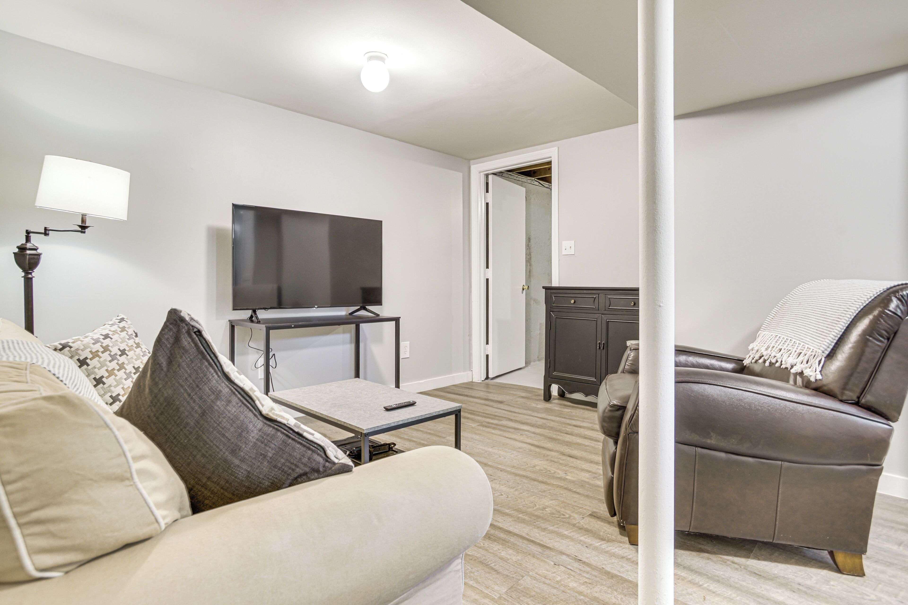 Un salon comprenant un canapé, une table basse, un téléviseur et un meuble.
