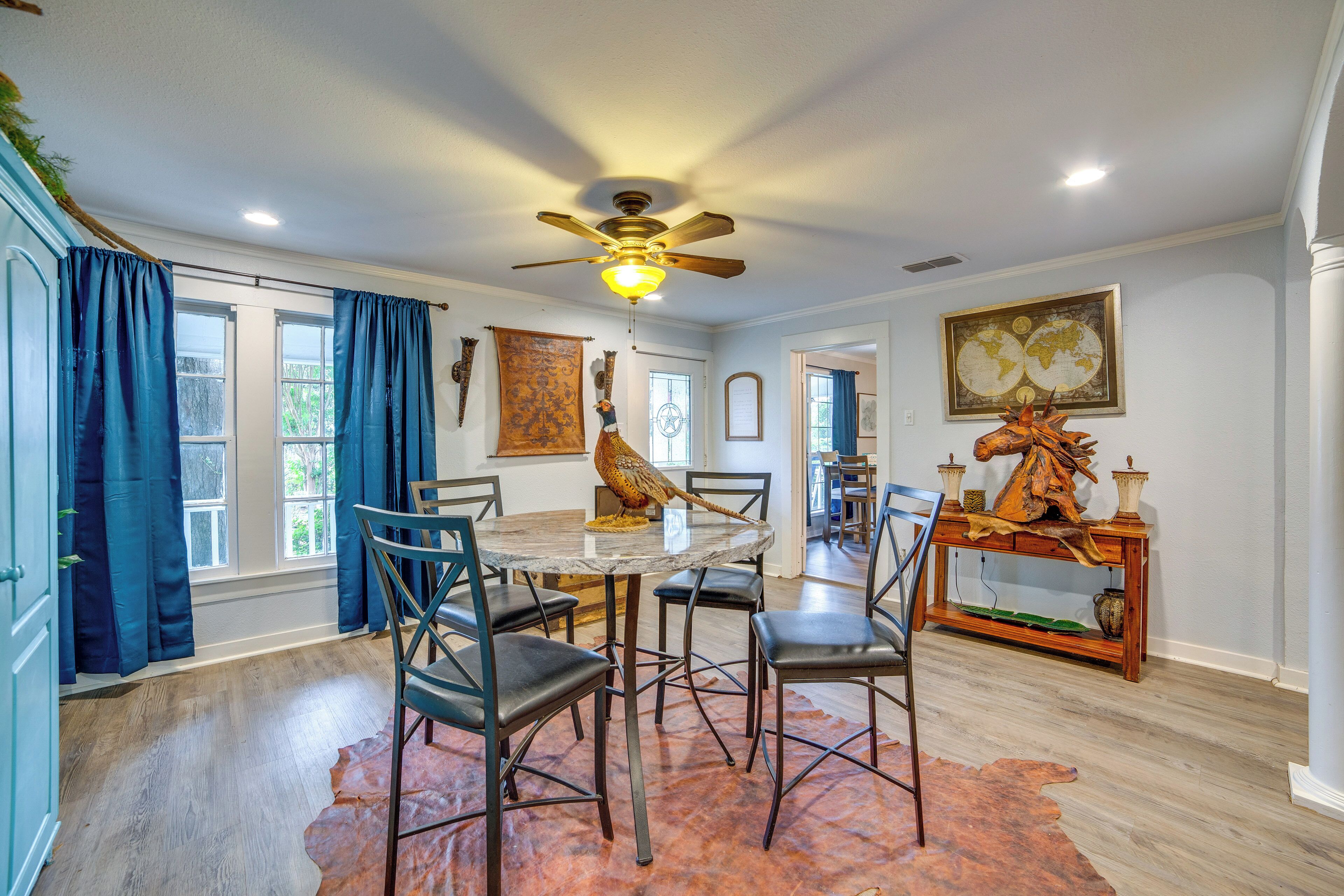 A dining area with a round table, chairs, and a ceiling fan.
