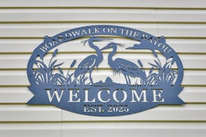 A decorative sign with the text "Boardwalk on the Bayou Welcome EST. 2025" against a striped background. - Canal-front Abode w/ Private Dock in Bay St Louis (Bay St Louis)