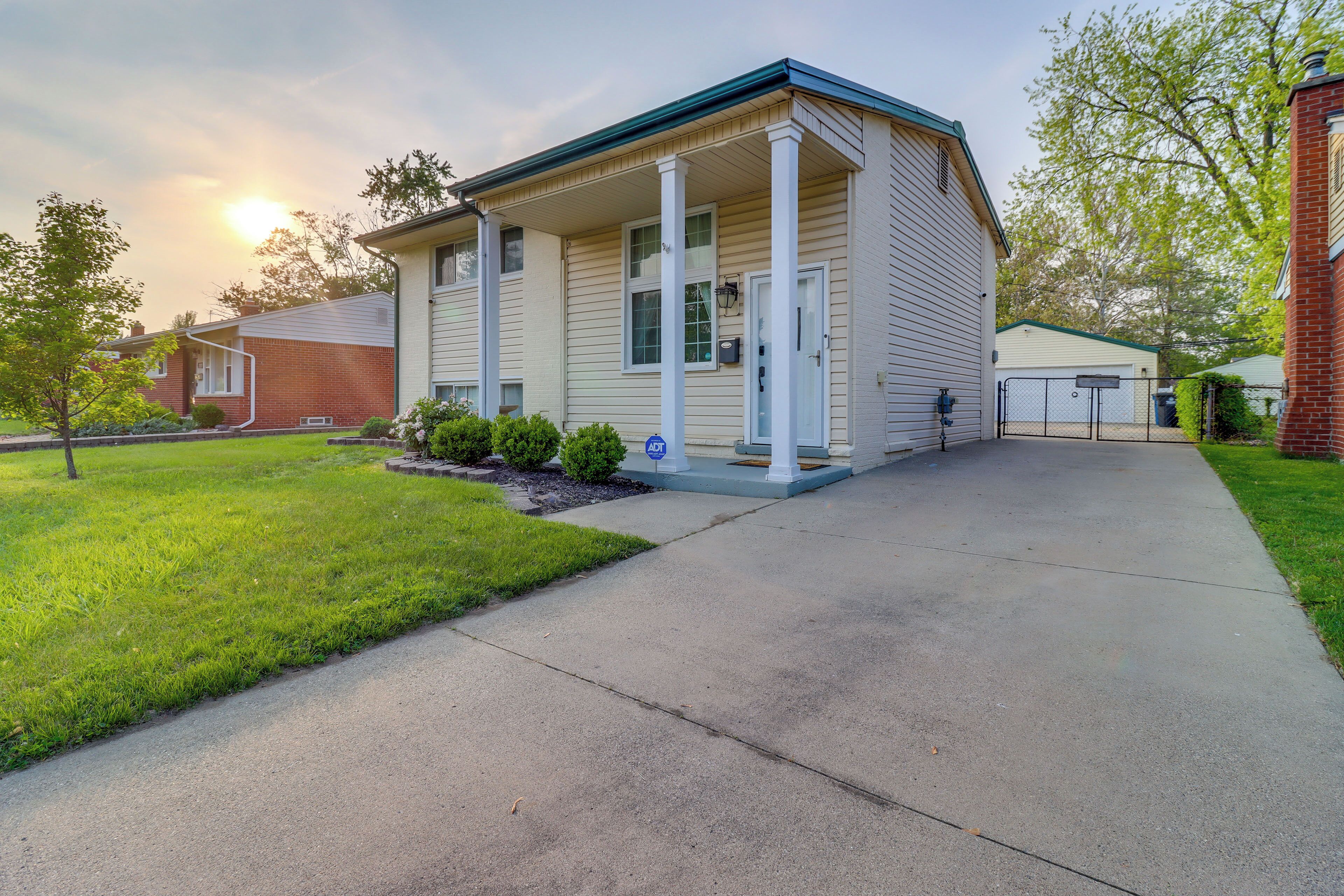 A two-story house with a front porch, a garage, and a well-maintained lawn.