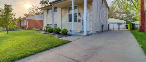 A two-story house with a front porch, a garage, and a well-maintained lawn.