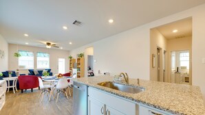 A modern kitchen with granite countertops, white cabinetry, and a built-in sink. - 3 Mi to Dtwn Kyle: Wfh-friendly Home w/ Patio (Kyle)