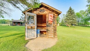 A rustic log cabin with a wooden door open, revealing a sauna inside. - 5-acre Kingston Getaway: Sauna & Fire Pit (Kingston)