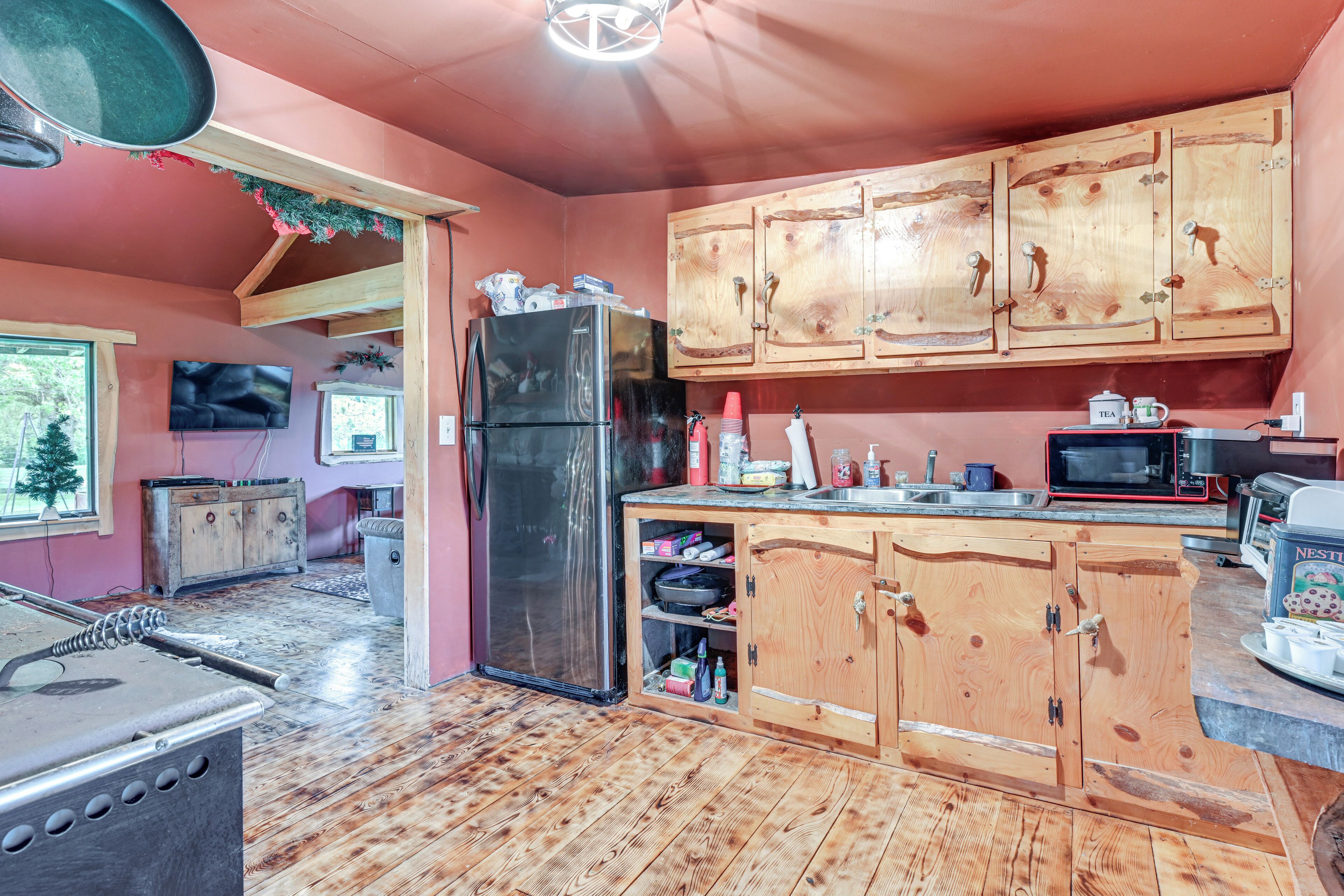 A kitchen with wooden cabinets, a refrigerator, a microwave, and a toaster.
