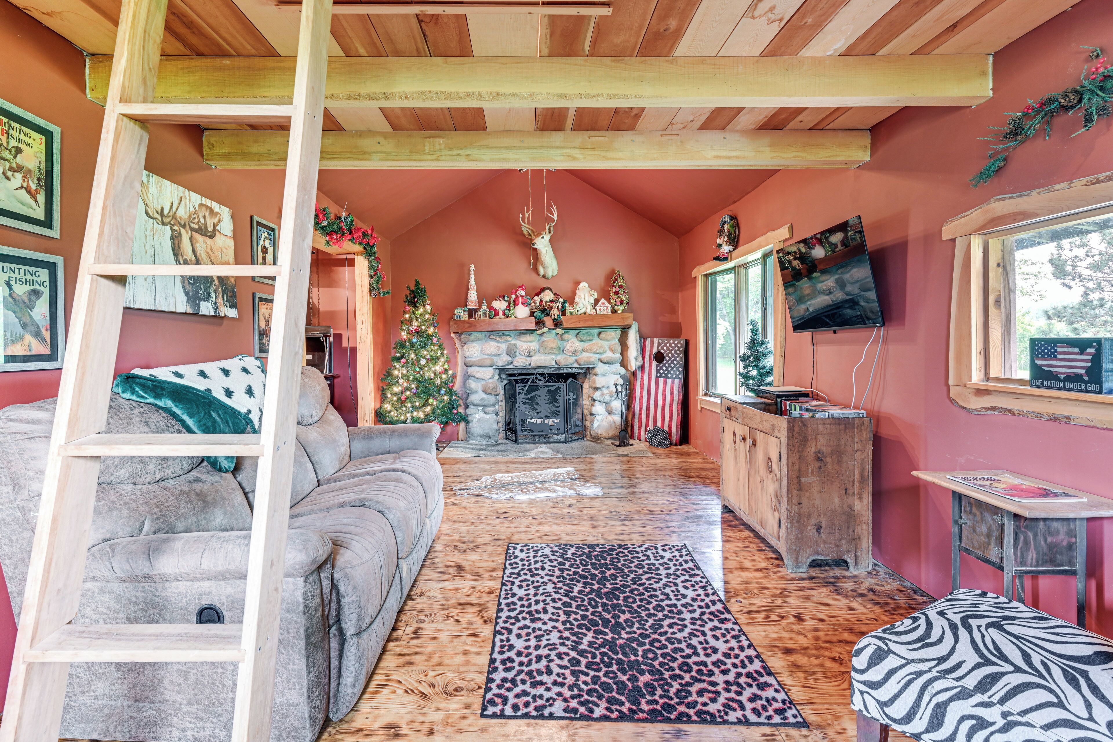 Een gezellige woonkamer met een open haard, een kerstboom en een ladder.