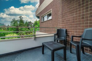 A balcony with a view of greenery and a brick wall. - Stylish 2-Bedroom Apartment by Lake Como (Como)