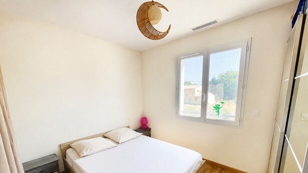 A bedroom with a bed, a nightstand, a window, and a ceiling fan. - Lorgues: 3-BR house, private pool, A/C & fiber Wi-Fi (Lorgues)