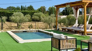 A pool with a wooden deck, lounge chairs, and a pergola with a sign. - Lorgues: 3-BR house, private pool, A/C & fiber Wi-Fi (Lorgues)