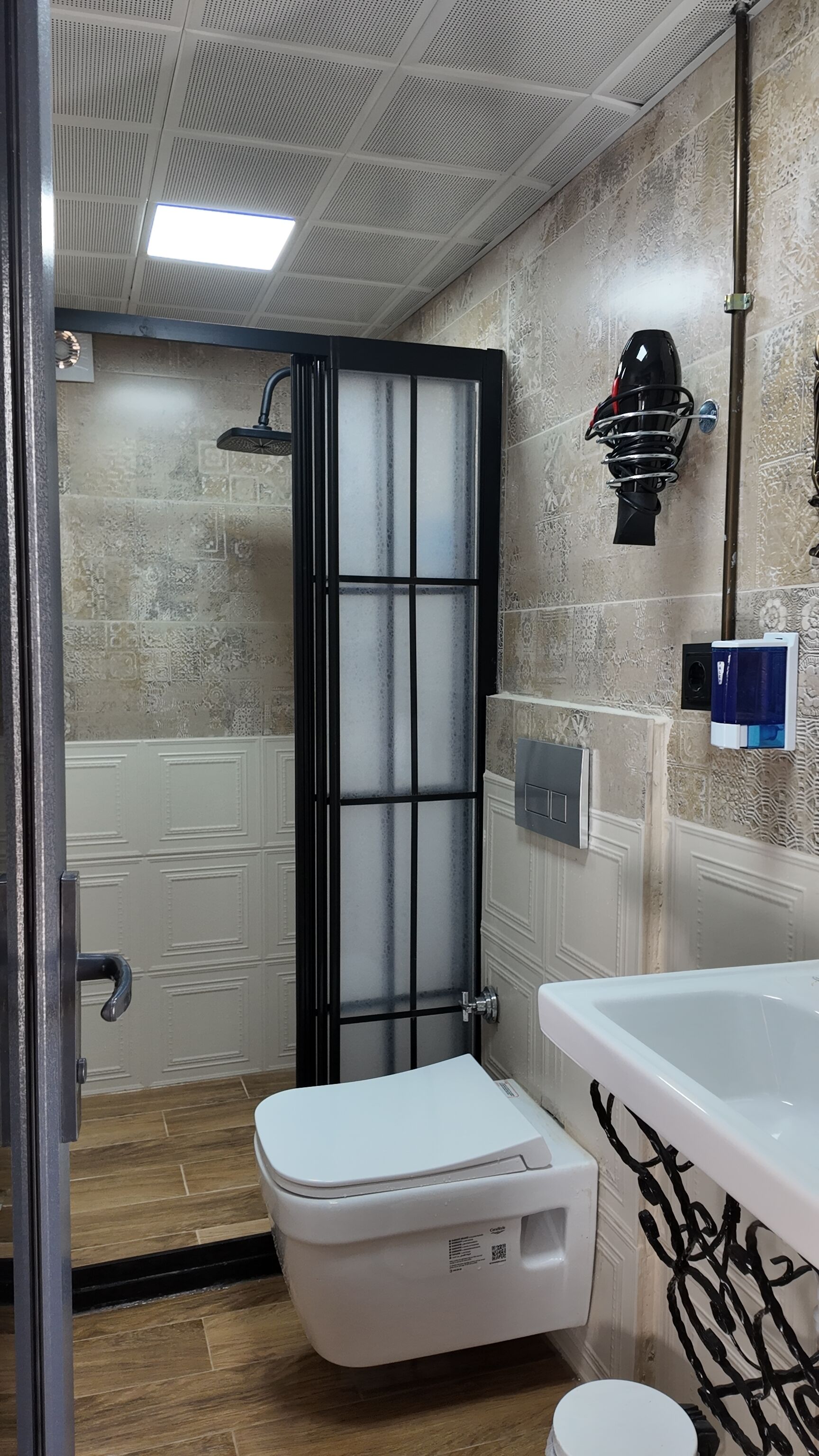 Une salle de bain avec douche, toilettes et lavabo.