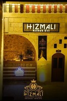 Un área de recepción con un letrero que dice “HIZMALI Konuk Evi” y un banderín con el mismo nombre.