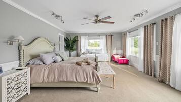 Une chambre à coucher avec un lit, une table de chevet, une lampe et une vue sur l’extérieur.